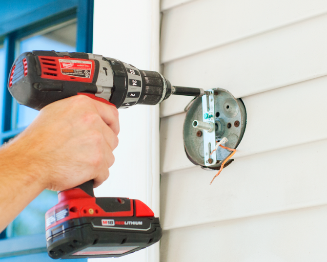 How To Install An Exterior Lighting Fixture Angie S List Securing Exterior Light Mounting Bracket With Drill